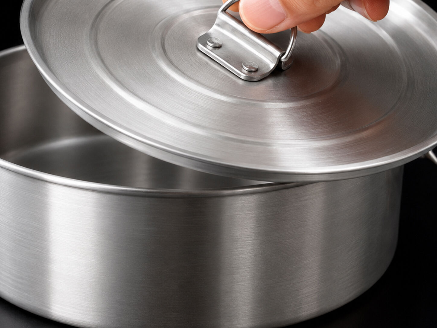 Close-up of a hand lifting the fitted lid off the Globe Rocket flan mold