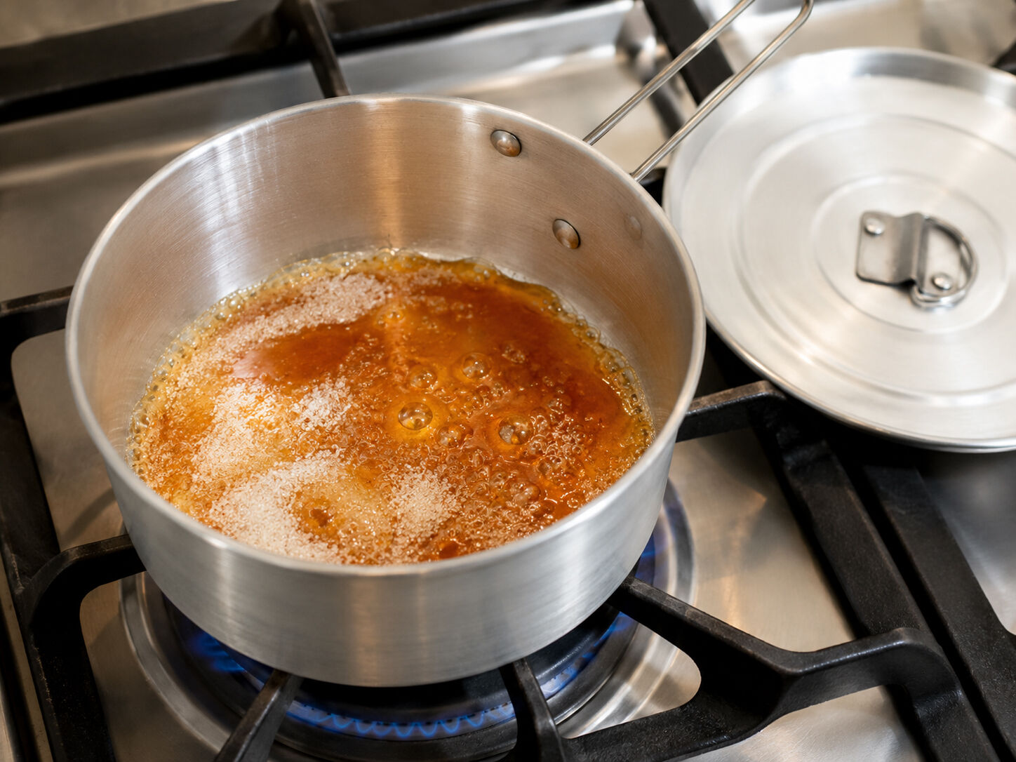 Sugar caramelizing directly in the aluminum flan mold on a stovetop burner