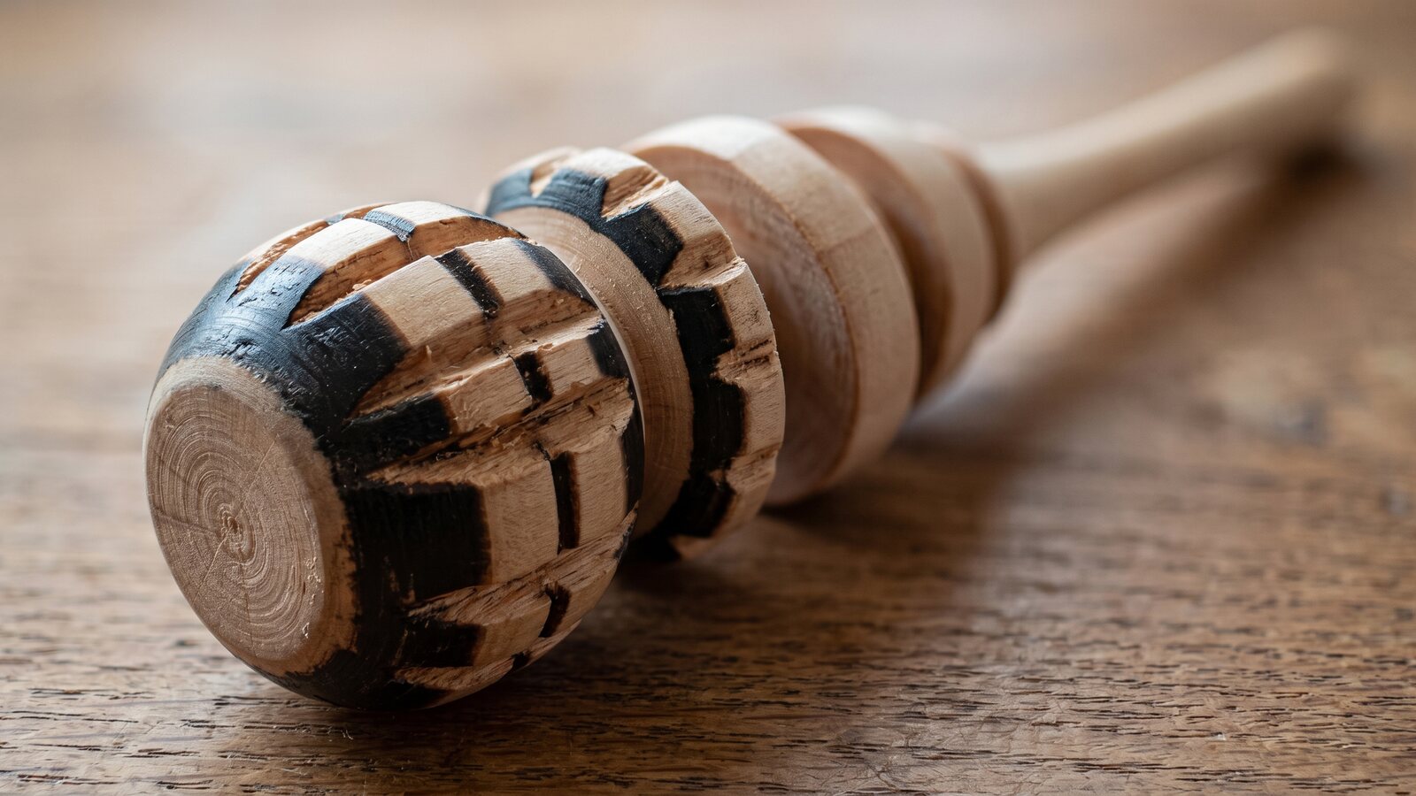 Close-up of a molinillo's carved rings and turned wood shaft, showing the single-piece construction