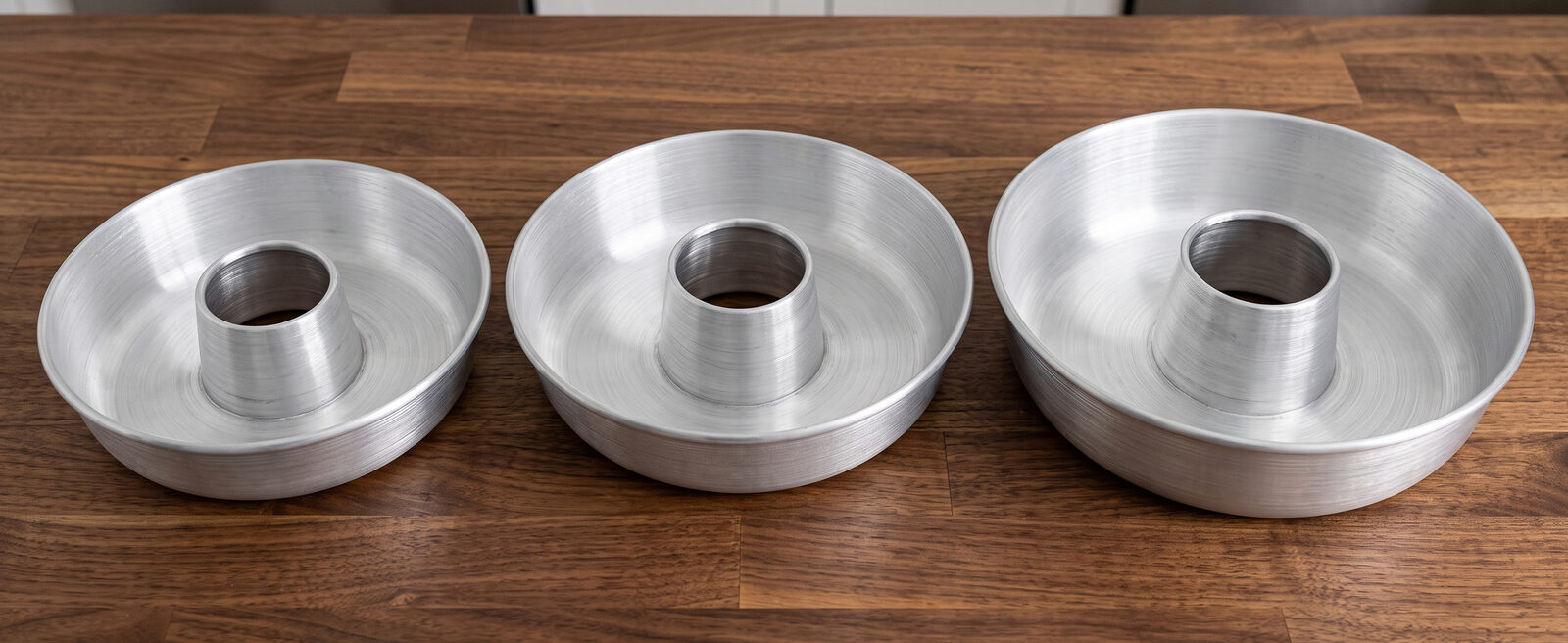 Three Globe Rocket aluminum ring cake pans of different sizes arranged together
